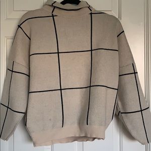 Plaid cream and black pullover sweater.